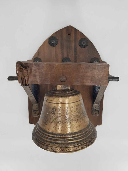 Ancienne cloche d'école en bronze sur un support en bois