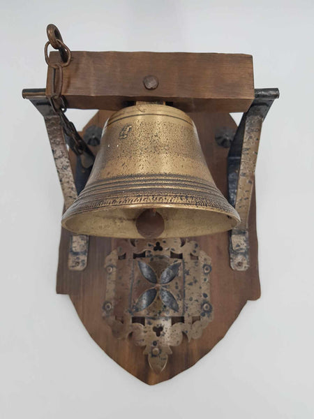 Ancienne cloche d'école en bronze sur un support en bois