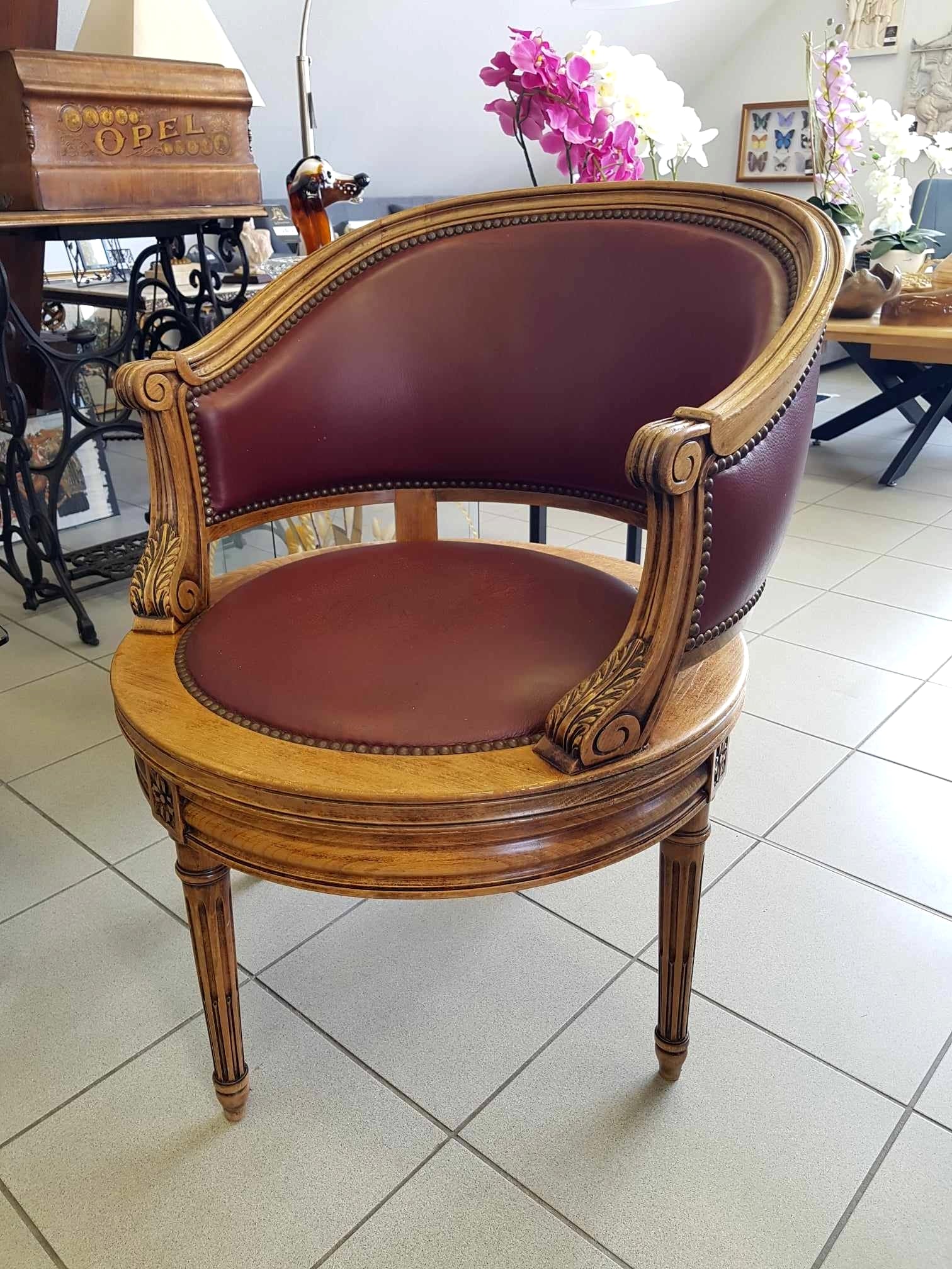 Fauteuil pivotant de style Louis XVI en bois de noyer et cuir clouté