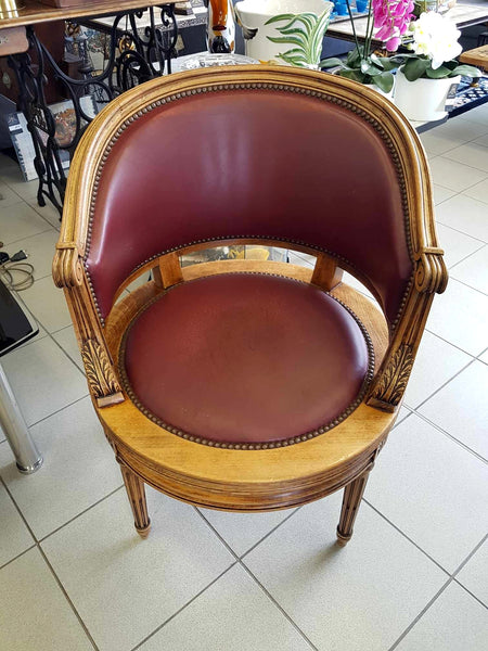 Fauteuil pivotant de style Louis XVI en bois de noyer et cuir clouté