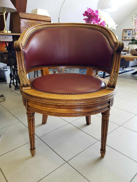 Fauteuil pivotant de style Louis XVI en bois de noyer et cuir clouté