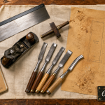 Outils pour menuisier : scie, varlope et ciseaux sur établi